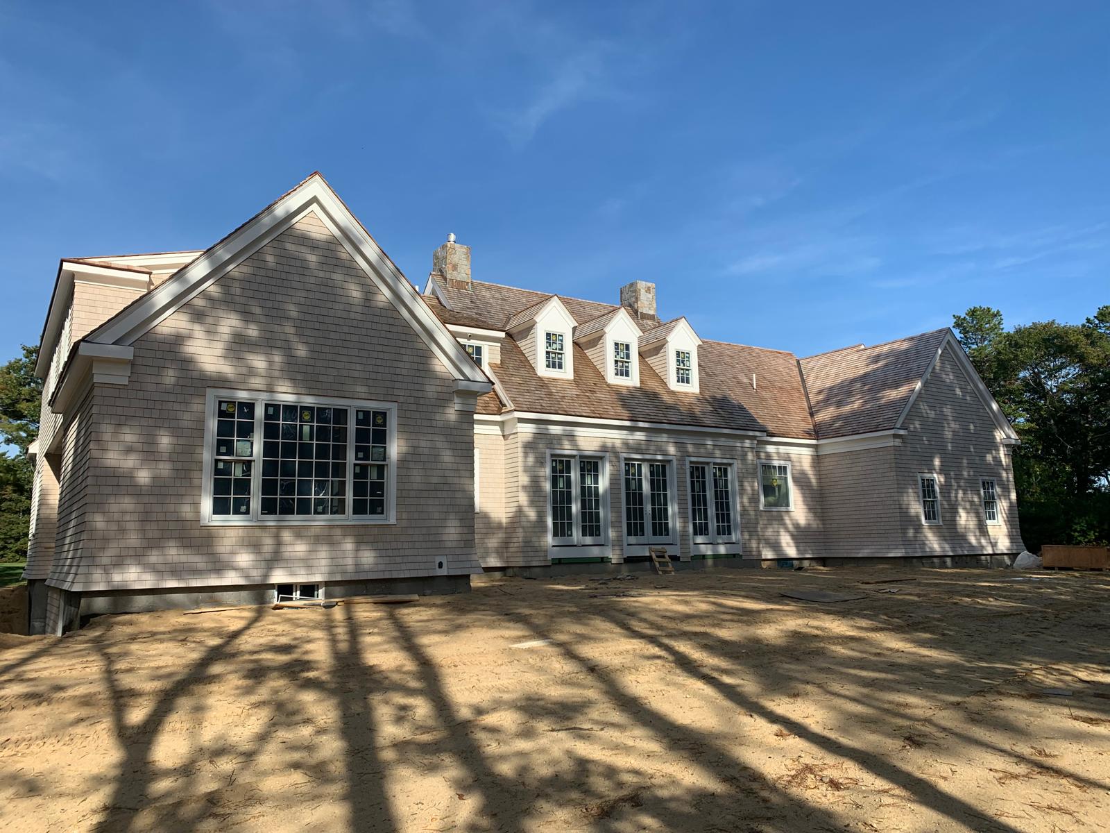Shingle style estate across the back lawn in low sun