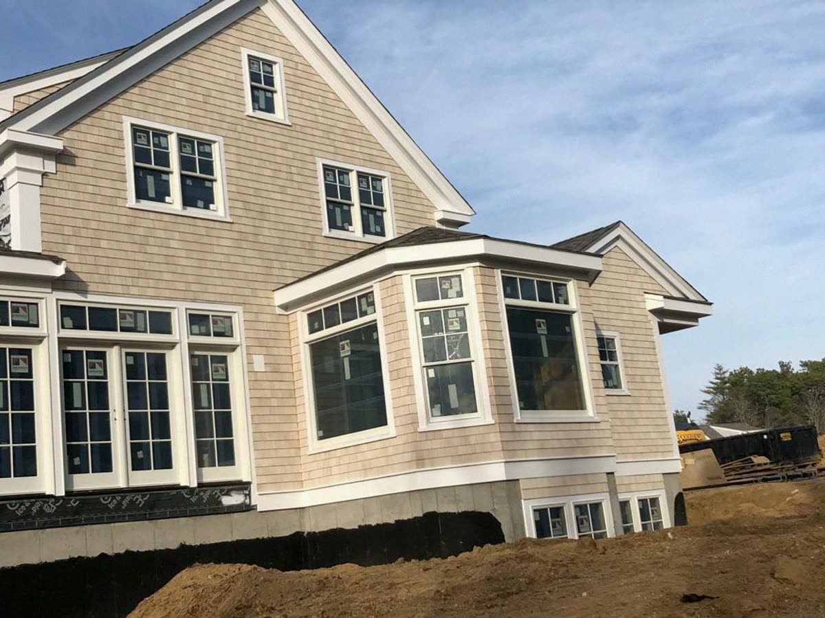 Shingle style home with bay window and white casing